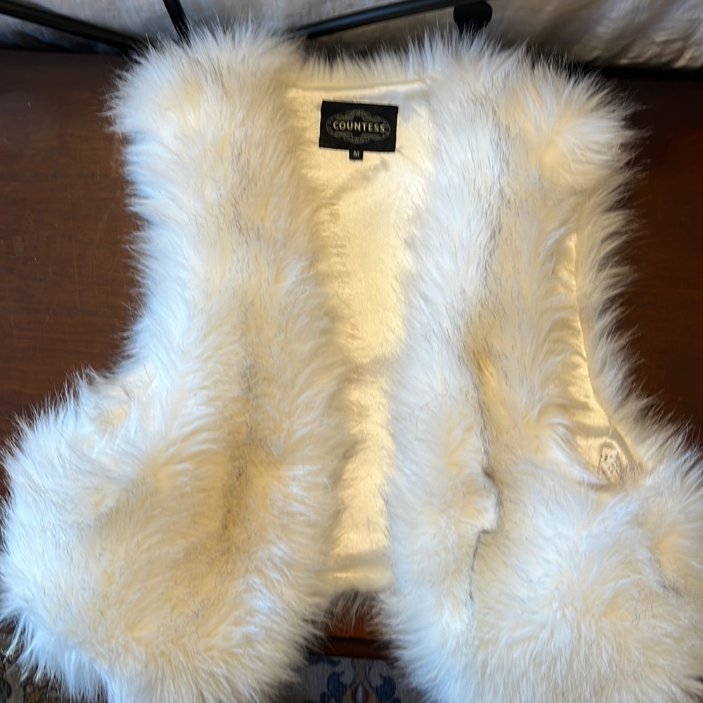 Faux white fur vest.